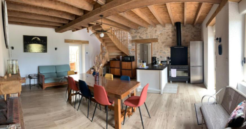 gîte rénové avec poutres apparentes et murs en pierre, avec un style mêlant l'ancien et le moderne