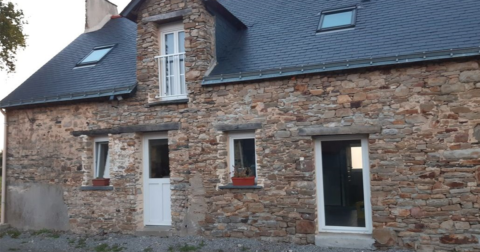 maison ancienne en pierre avec huisseries blanches et linteau en bois, toit en ardoise