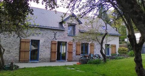 longère en pierre, volets en bois et huisseries bleues, terrasse, jardin avec arbres