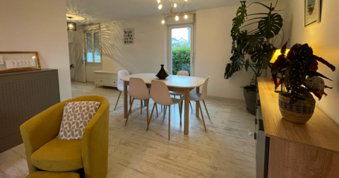 maison avec intérieur contemporain cosy, meuble en bois, fauteuil jaune, table et chaise en bois et résine blanche