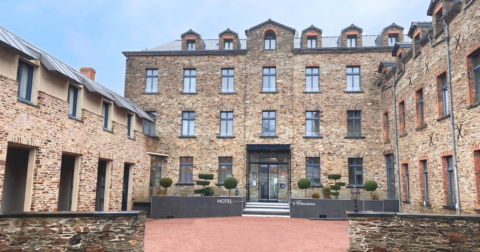 grand hôtel en brique avec huisseries grises et entrée vitrée