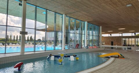 pataugeoire avec jeux d'eau devant une grande baie vitrée de la piscine
