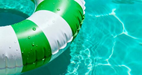 bouée ronde verte et blanche flottant dans une piscine