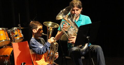 Un élève instrumentiste sur scène accompagné de son professeur