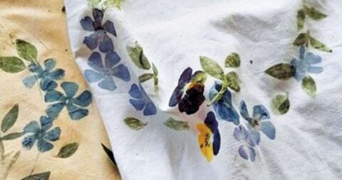 tissu blanc avec impressions de feuilles vertes et de fleurs bleues