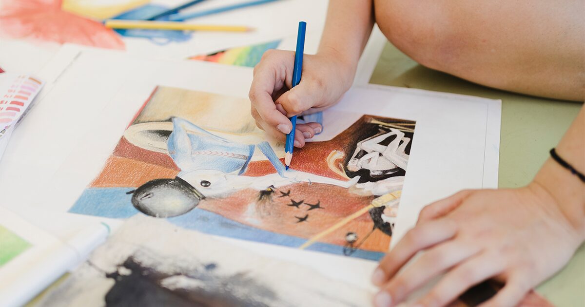 un enfant crayonnant sur un dessin au sol