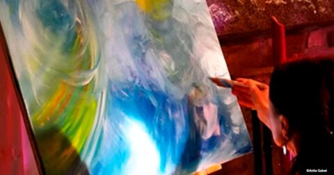 artiste peignant sa toile mutlicolore