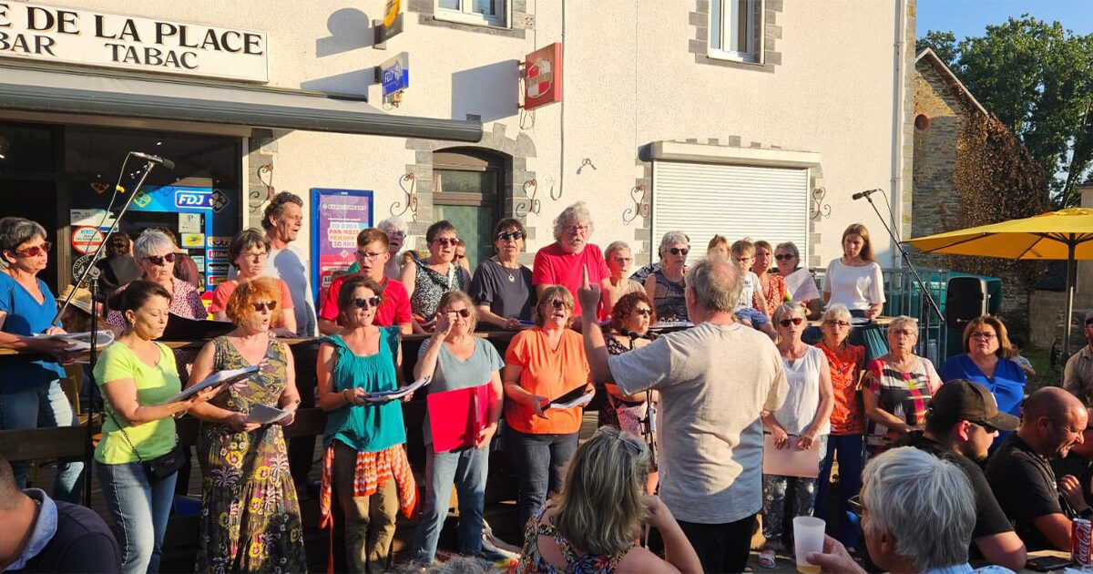 chorale d'adultes chantant sur place de village pour la fête de la musique