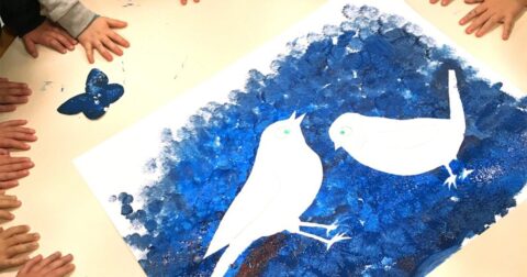 dessin d'oiseaux bleus réalisés au pochoir sur une table jaune