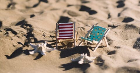 Deux mini transats et coquillages posés sur une plage