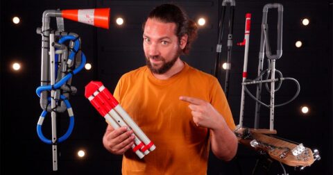 Un homme barbu avec t-shirt orange entouré de matériels de bricolage faits maison