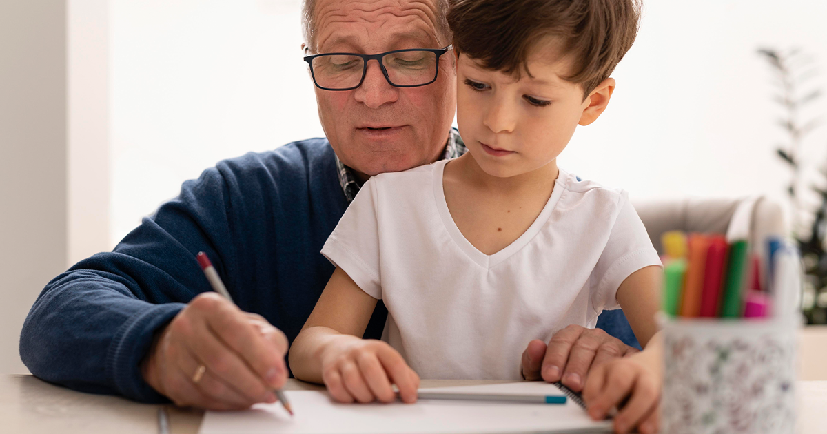 petit garçon et son grand-père écrivant ensemble sur une feuille