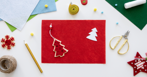 création d'une carte de Noël en cours avec ciseaux, papiers...