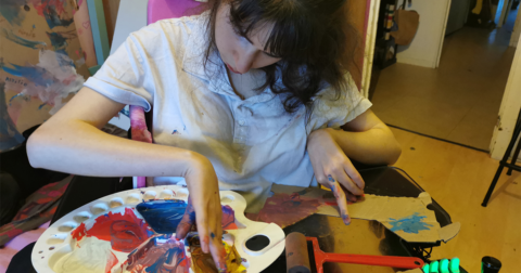 jeune fille handicapée assise à son atelier de peinture