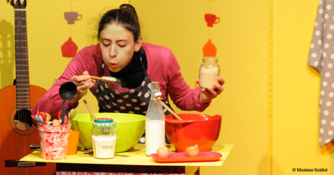comédienne dans une cuisine de théâtre préparant un gâteau