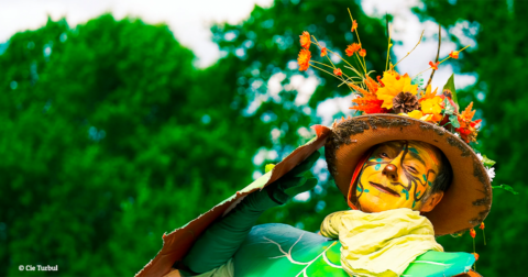 comédien déguisé en tenue verte et chapeau à fleurs