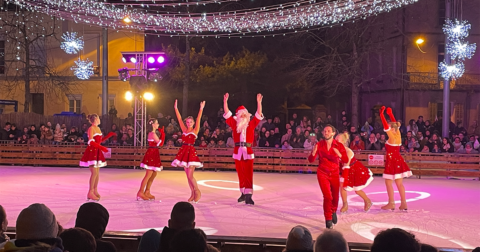 Un Père Noël et 4 danseuses déguisés sur une patinoire en plein air de nuit